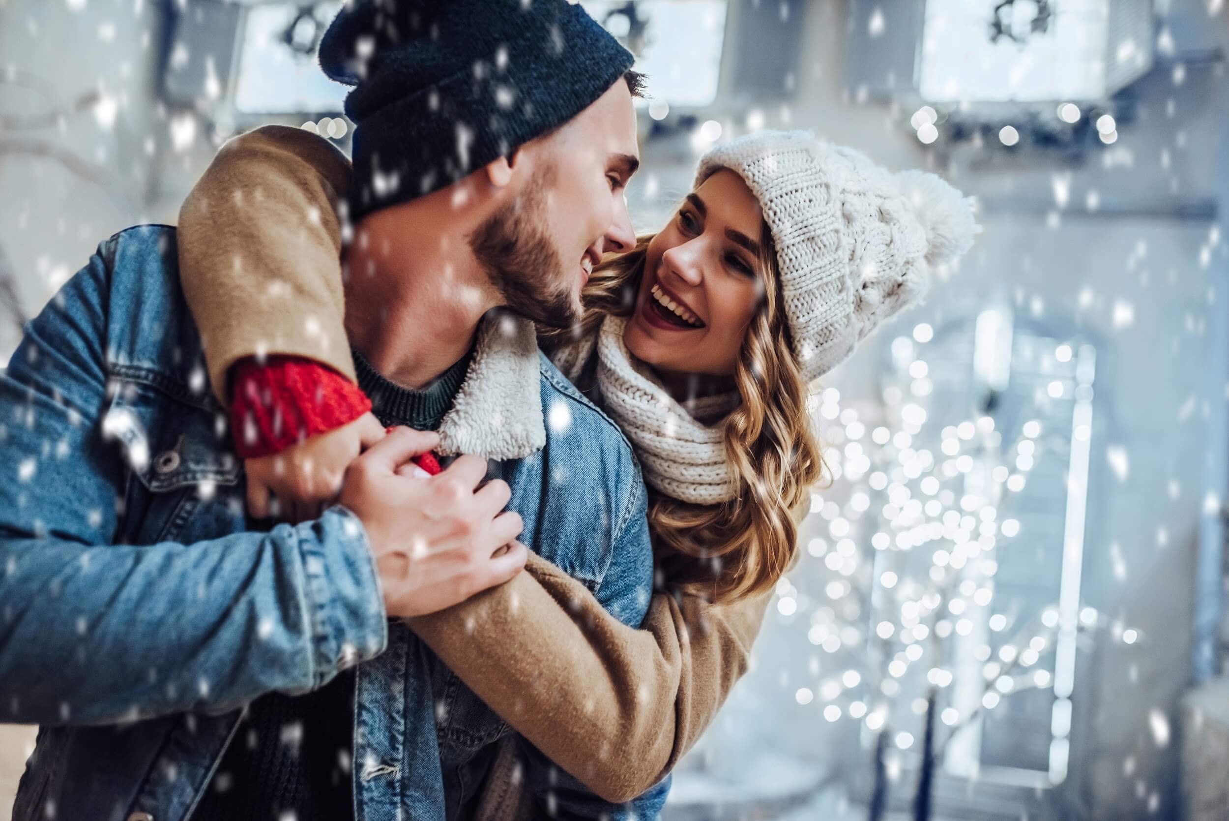 Couple in the snow smile at each other